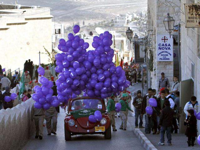 A car loaded with balloons to be given to residents as part of the Christmas celebrations near The Church of the Nativity in West Bank town of Bethlehem. Reuters/Mohamad Torokman