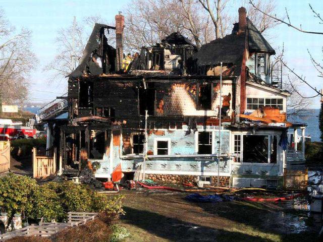 Firefighters investigate a house where an early morning fire left five people dead in Stamford, Connecticut. AP Photo