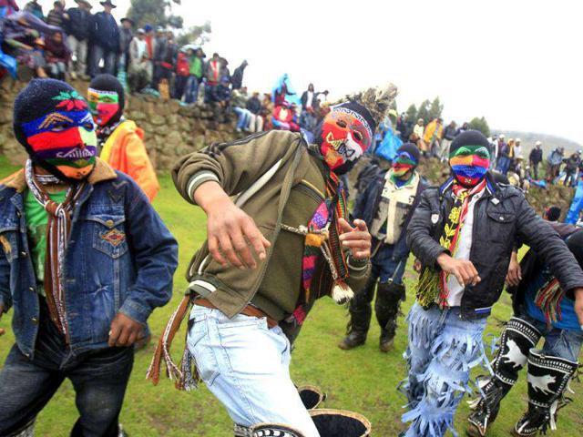 Andean men wearing masks dance while entering the ring to participate in fights during the "Takanakuy", a traditional festivity at Chumbivilcas province in Cuzco.