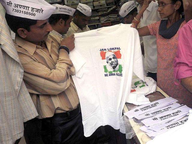 A supporter of Anna Hazare chooses a t-shirt printed with his photo ahead of a 3 day-long fast in Mumbai. AFP Photo