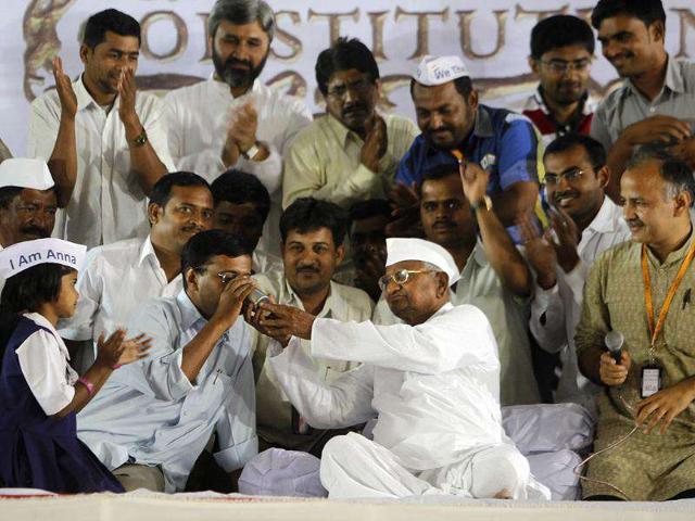 Anti-corruption activist Anna Hazare offers a glass of juice to Arvind Kejriwal as they end their fast in Mumbai. (AP Photo/Rafiq Maqbool)