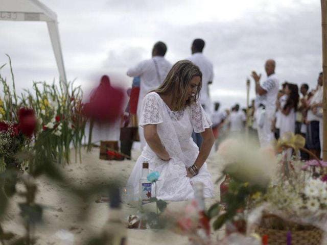A follower of Afro-Brazilian religion Umbanda goes into a trance during a ceremony in tribute to Iemanja, the goddess of the sea, in Copacabana Beach in Rio de Janeiro.