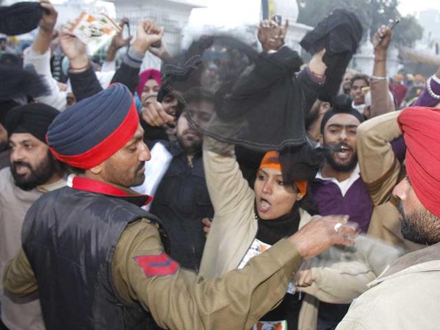 Policemen trying to stop Anna supporters who were showing the black flags and raising anti-Prime Minister slogans during his Harmandar Sahib (Golden Temple) visit in Amritsar on Sunday wee hours. HT Photo/Munish Byala