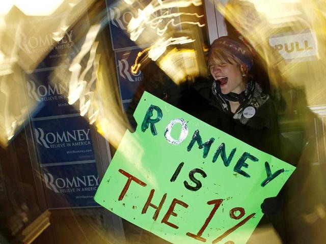 A protester yells with a placard outside Republican presidential candidate and former Massachusetts Governor Mitt Romney's office in Des Moines, Iowa.
