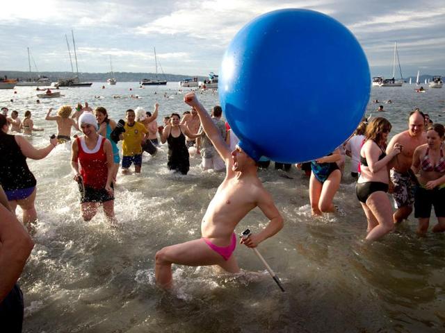 Participants take to the frigid waters of English Bay during the 92nd annual Polar Bear Swim in Vancouver, B.C.. (AP Photo/The Canadian Press, Darryl Dyck)