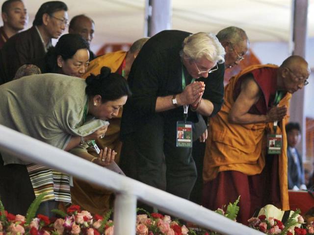 Hollywood actor Richard Gere, center, bows in respect as Tibetan spiritual leader the Dalai Lama, unseen, walks past during the Kalachakra Buddhist festival in Bodh Gaya, Bihar. Bodh Gaya, is believed to be the place where Buddha attained enlightenment. AP Photo/Altaf Qadri