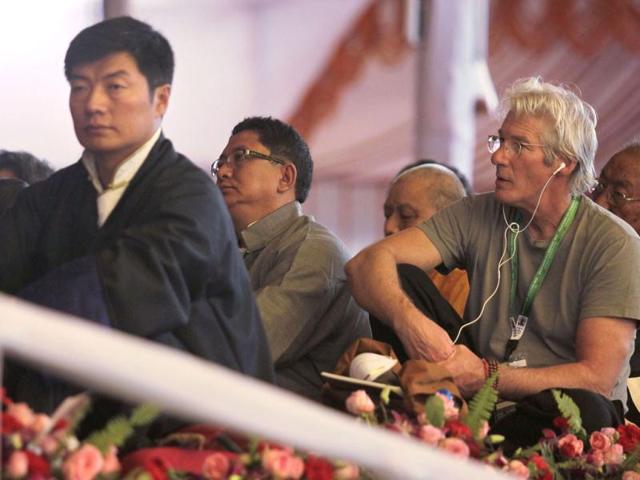 Prime Minister of the Tibetan government-in-exile Lobsang Sangay, left, and Hollywood actor Richard Gere, right, attend a teaching session by Tibetan spiritual leader the Dalai Lama during the Kalachakra Buddhist festival in the town of Bodh Gaya, believed to be the place where Buddha attained enlightenment, in the eastern state of Bihar, India, Thursday. (AP)