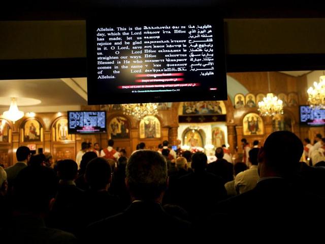 A television monitor displays English, Coptic and Arabic languages during Christmas Nativity Liturgy, the start of Christmas, at the Coptic Orthodox Church of St. George in the Brooklyn borough of New York City. Like the Eastern Orthodox Church in Russia, Copts still use the Julian calendar and thus celebrate Christmas on January 7. St. George Church, like other Coptic churches around the country, has witnessed a surge of Christians fleeing Egypt since the start of the Arab Spring. Spencer Platt/Getty Images/AFP