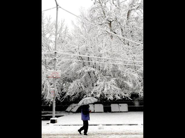 A Kashmiri man walks down a snow-covered street during snowfall in Srinagar. AFP Photo
