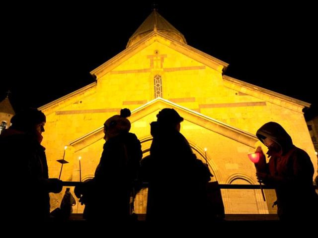 People hold candles during the Orthodox Christmas service at Sioni Cathedral in Tbilisi. (AFP Photo/Vano Shlamov)