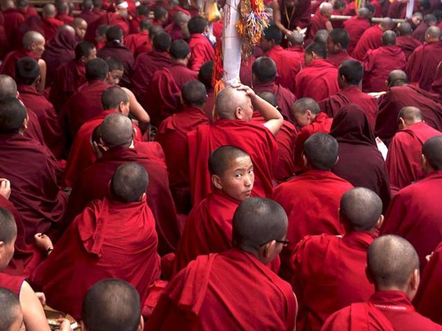 A Buddhist nun looks back as they watch a Kalachakra ritual dance during the Kalachakra Buddhist festival in the town of Bodh Gaya, believed to be the place where Buddha attained enlightenment, in Bihar. (AP Photo/Altaf Qadri)