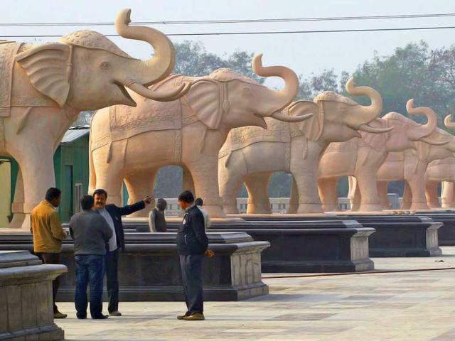 Local officials discuss their next course of action near statues of elephants at a park in Noida, Uttar Pradesh. AP/Saurabh Das