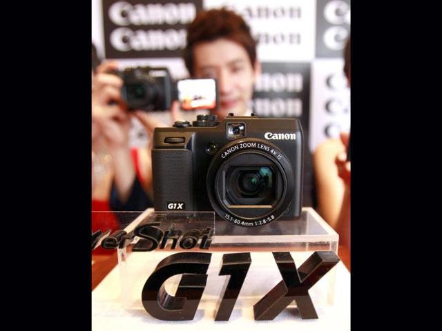 A model poses with Canon's new digital camera Power Shot G1 X during its unveiling ceremony in Seoul, South Korea. (AP Photo/Lee Jin-man)