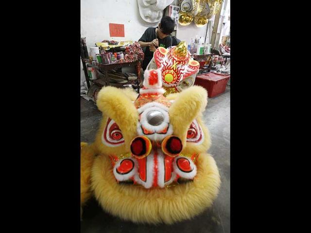 A worker makes a Chinese lion head used for the lion dance in the upcoming Chinese New Year celebrations in Shah Alam, outside Kuala Lumpur, Malaysia. AP Photo/Lai Seng Sin.