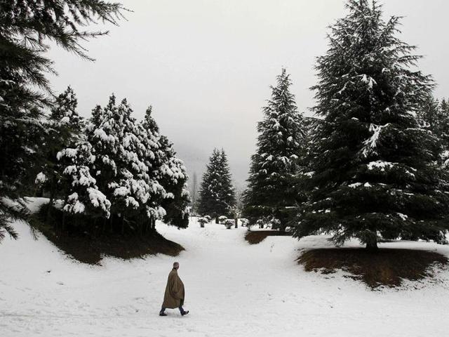 A man walks on a snow covered field on the outskirts of Srinagar. AP Photo/Mukhtar Khan