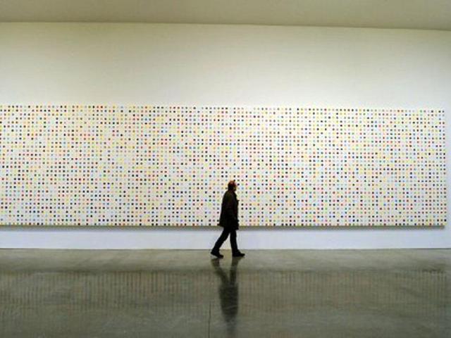 A man walks past a painting titled Urea-13C during a media preview of The Complete Spot Paintings 1986–2011 by artist Damien Hirstat at the Gagosian Gallery in New York. AFP/Timothy A Clary