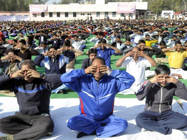 Madhya Pradesh chief minister Shivraj Singh Chouhan (C) joins school children in a mass surya namaskar yoga exercise in Bhopal. (AFP Photo)