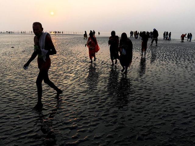 Pilgrims walk back after peforming rituals at the Gangasagar some 155km south of Kolkata. Thousands of pilgrims have started to converge for the Gangasagar Mela which will culminate in a dip in the ocean at the confluence of the River Ganges and the Bay of Bengal on the occasion of Makar Sankranti. AFP photo/Dibyangshu Sarkar