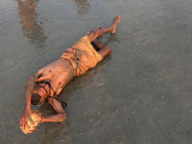 A sadhu (holy man) peforms rituals at the Gangasagar some 155km south of Kolkata. Thousands of pilgrims have started to converge for the Gangasagar Mela which will culminate in a dip in the ocean at the confluence of the River Ganges and the Bay of Bengal on the occasion of Makar Sankranti. AFP photo/Dibyangshu Sarkar