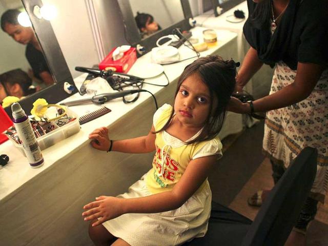 A child model gets her hair done backstage before a show at India Kids Fashion Week in Mumbai. Reuters/Danish Siddiqui.