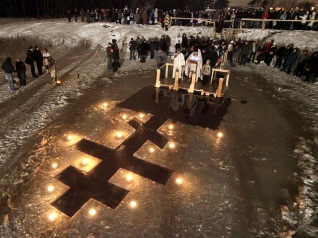 Russian Orthodox priests conduct a service on Epiphany at a pond in Tyarlevo village outside St. Petersburg, Russia. Thousands of Russian Orthodox Church followers plunged into icy rivers and ponds across the country to mark Epiphany, during which they cleanse themselves with water deemed holy for the day. Water that is blessed by a cleric on Epiphany is considered holy and pure until next year's celebration, and is believed to have special powers of protection and healing. AP Photo/Dmitry Lovetsky