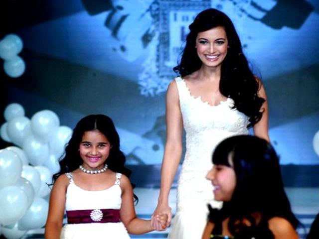 Dia-holds-a-little-girl-s-hand-as-she-walks-the-ramp-for-Rocky-S