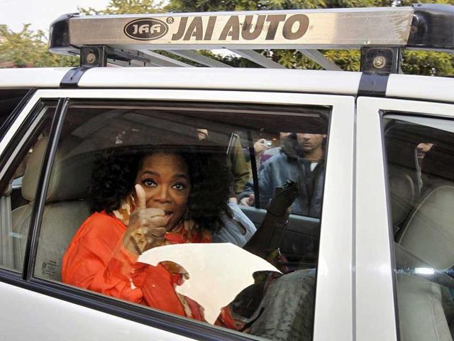 Oprah Winfrey is visibly excited as she gestures to the media while leaving the Taj Mahal. (AP)