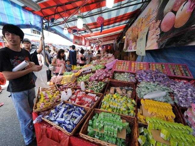 A vendor selling sweets and candies waits for customers at a bazaar on the eve of the Lunar New Year of the Dragon in Singapore. The Chinese Lunar New Year of the dragon falls on January 23 and 24 in Singapore. (AFP Photo)
