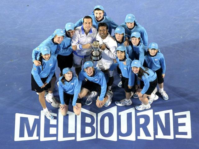 Leander Paes and Radek Stepanek of the Czech Republic hold the trophy, surrounded by ball boys and girls during the awarding ceremony after defeating USA's Bob Bryan and Mike Bryan in their men's doubles final at the Australian Open tennis championship, in Melbourne. (AP Photo/John Donegan)