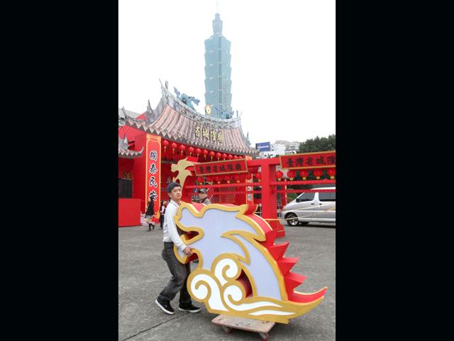 A worker transports part of a dragon lantern in preparation for Taipei Lantern Festival of the Chinese Lunar New Year of the Dragon in Taipei, Taiwan. The festival opens for Feb. 2-12. (AP Photo/Chiang Ying-ying)