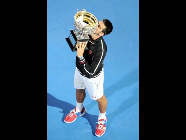 Novak Djokovic of Serbia kisses the trophy following his victory over Rafael Nadal of Spain in the men's final match at Australian Open in Melbourne. (AFP photo/William West)