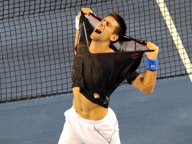 Novak Djokovic of Serbia rips his shirt off as he celebrates his victory over Rafael Nadal of Spain in the men's final match at Australian Open in Melbourne. (AFP photo/William West)