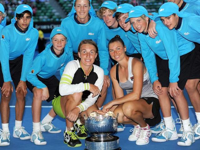 Svetlana Kuznetsova of Russia (centre L) and Vera Zvonareva of Russia (centre R) pose with the trophy and "ballkids" after defeating Sara Errani of Italy and Roberta Vinci of Italy in the women's doubles final at Australian Open tennis tournament in Melbourne. (AFP photo/Greg Wood)
