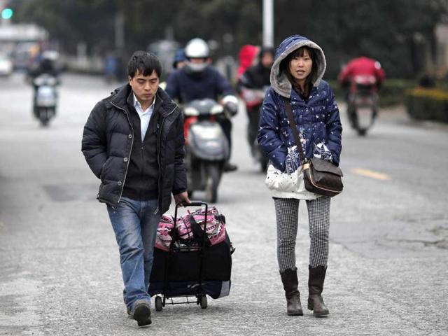 Workers walk with their belongings as they return to work after the Chinese New Year holidays in Shanghai. Reuters/Carlos Barria