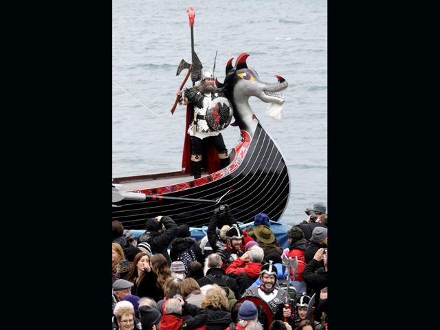 'Guizer Jarl' David Nicholson, leader of the 'Jarl Squad', stands aboard his longboat next to its beast-head prow during the annual Up Helly Aa festival in Lerwick, Shetland Islands. (AFP PHOTO/Andy Buchanan)