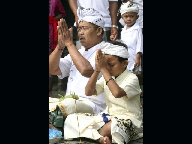 A Balinese father prays with his son during Hindu festival of Galungan, celebrating the triumph of good over evil at a temple in Denpasar, Bali, Indonesia. AP Photo/Firdia Lisnawati