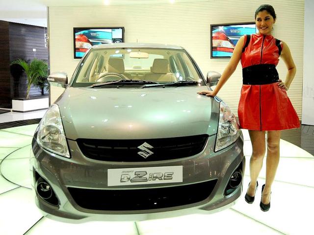 A model poses with the newly unveiled Swift DZire in New Delhi. Maruti Suzuki unveiled the all new compact, powerful and more fuel efficiant Swift DZire entry level sedan with K-12 VVT petrol engine and a D13A intercooler turbocharger DDiS diesel engine. AFP/Prakash Singh