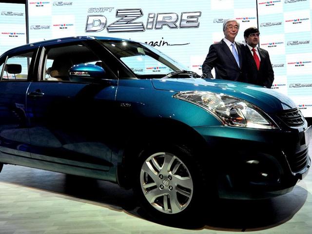 Managing director and CEO of Maruti Suzuki India Shinzo Nakanishi (L) and executive director of Maruti Suzuki India Mayank Pareek (R) pose with newly unveiled Swift DZire in New Delhi. AFP Photo/Prakash Singh