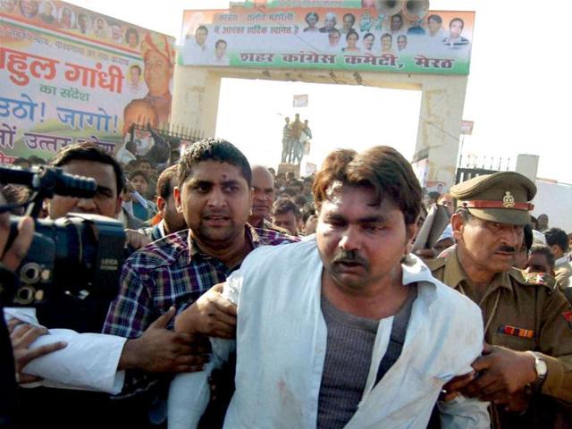 People take away a man who waved black flag during Congress general secretary Rahul Gandhi's election rally in Meerut. PTI Photo