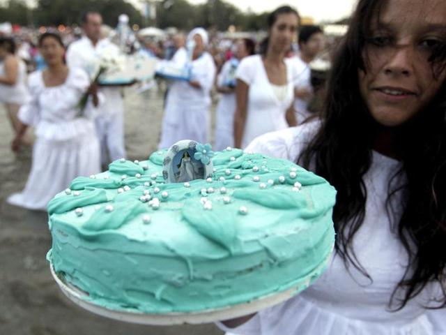 A devotee holds up a cake used to pay tribute to the Afro-Brazilian goddess of the sea Lemanja on Lemanja Day at Ramirez beach in Montevideo. Reuters/Andres Stapff