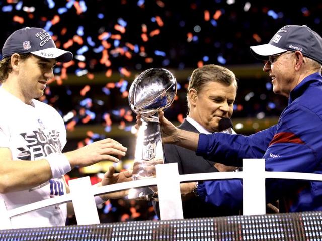 New York Giants head coach Tom Coughlin, right, hands the Vince Lombardi Trophy to quarterback Eli Manning after their 21-17 win over the New England Patriots in the NFL Super Bowl XLVI football game, Sunday, Feb. 5, 2012, in Indianapolis. AP/David J. Phillip