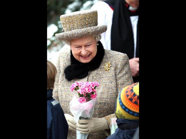 Britain's Queen Elizabeth II accepts a bouquet of flowers from a well wisher at the church of St Peter and St Paul at West Newton, eastern England. The queen braved the cold and snow to attend church Sunday on the eve of her Diamond Jubilee anniversary. AP/PA, Chris Radburn