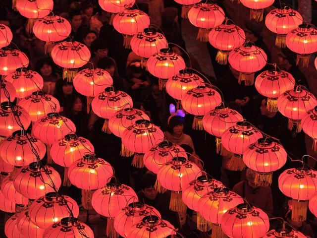 A woman wears a novelty hairband as she walks under red lanterns during a Lantern Festival celebration at Confucian Temple of Nanjing, Jiangsu province. Reuters/Sean Yong