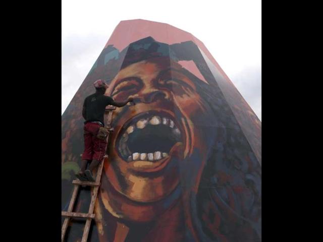 A worker paints a picture of Jamaican musician Bob Marley in a square along a street in Bata. February 6, 2012 marks the 67th birth anniversary of the reggae star. (Reuters)