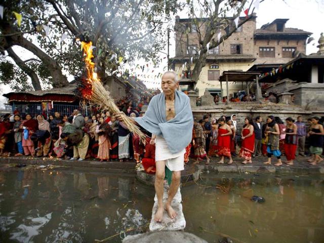 A devotee offers prayer at Bhaktapur during the Swasthani festival near Kathmandu. The month-long festival, dedicated to God Madhavnarayan and Goddess Swasthani, involves the recitation of folk tales about miraculous feats performed by them in many households. Reuters Photo/Navesh Chitrakar
