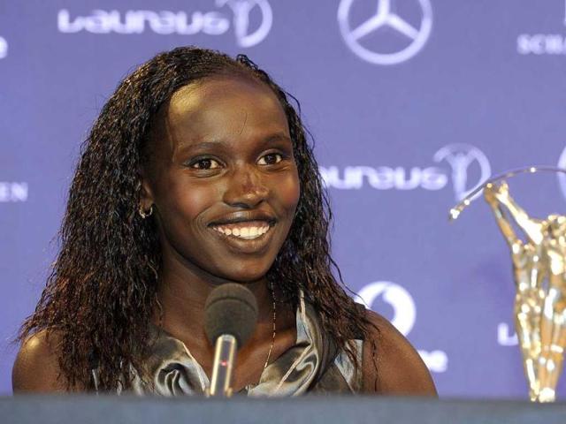 Kenyan athlete Vivian Cheruiyot sits next to her Sportswoman of the Year award as she talks to the media at the 2012 Laureus World Sports Awards in central London. Reuters/Paul Hackett 