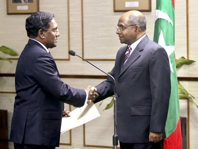 Mohammed Waheed Hassan, who previously worked as a top UNICEF official, left, shakes hands with Parliament Speaker Abdulla Shahid after being sworn-in as the country's new president in Male, Maldives. AP