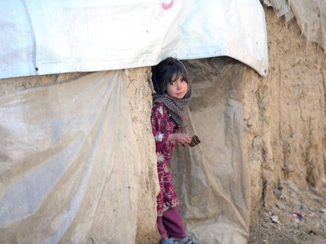 An internally displaced Afghan girl from Helmand province looks out from a mud shelter for the displaced at the Charhi Qambar refugee camp on the outskirts of Kabul. Fleeing NATO bombardment and Taliban intimidation, thousands of Afghans in refugee camps in the capital Kabul face a new enemy: an unusually bitter winter that is killing their children. AFP Photo/ Shah Marai