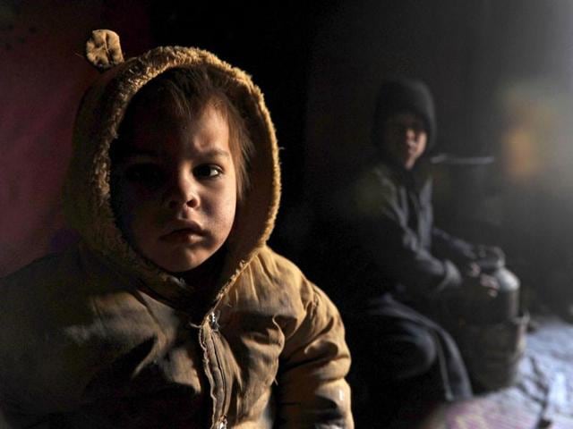 An internally displaced Afghan child from Helmand province is pictured inside a mud shelter for the displaced at the Charhi Qambar refugee camp on the outskirts of Kabul. Fleeing NATO bombardment and Taliban intimidation, thousands of Afghans in refugee camps in the capital Kabul face a new enemy: an unusually bitter winter that is killing their children. AFP Photo/ Shah Marai