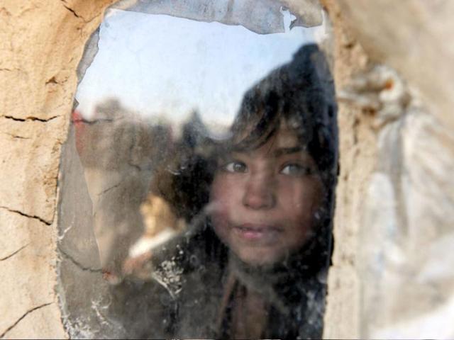 An internally displaced Afghan girl from Helmand province inside a mud shelter for the displaced looks out the window at the Charhi Qambar refugee camp on the outskirts of Kabul. Fleeing NATO bombardment and Taliban intimidation, thousands of Afghans in refugee camps in the capital Kabul face a new enemy: an unusually bitter winter that is killing their children. AFP Photo/ Shah Marai